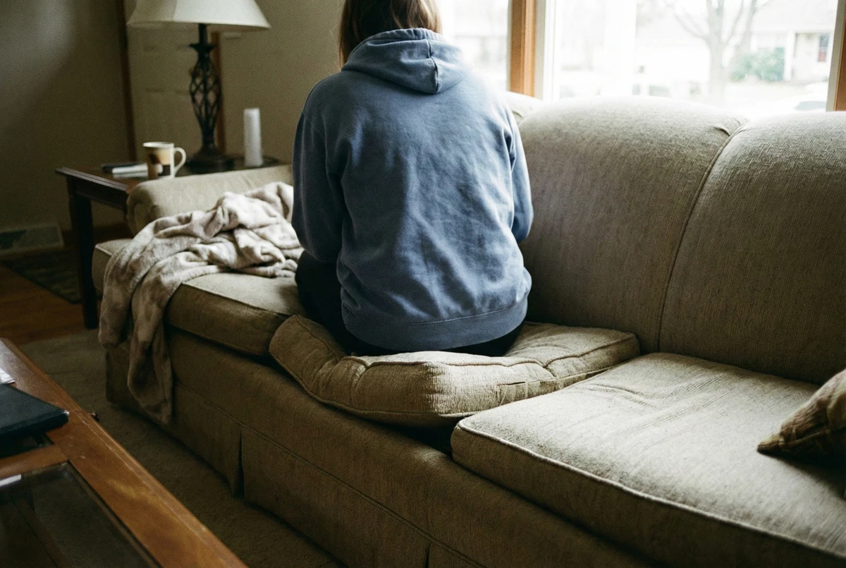 Someone sitting on visibly compressed sofa cushion casual photo